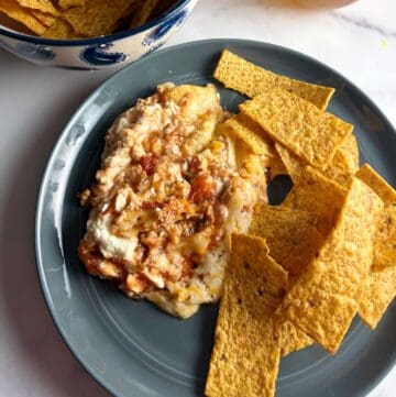 Easy Mexican dip with cream cheese on a plate, served with tortilla chips