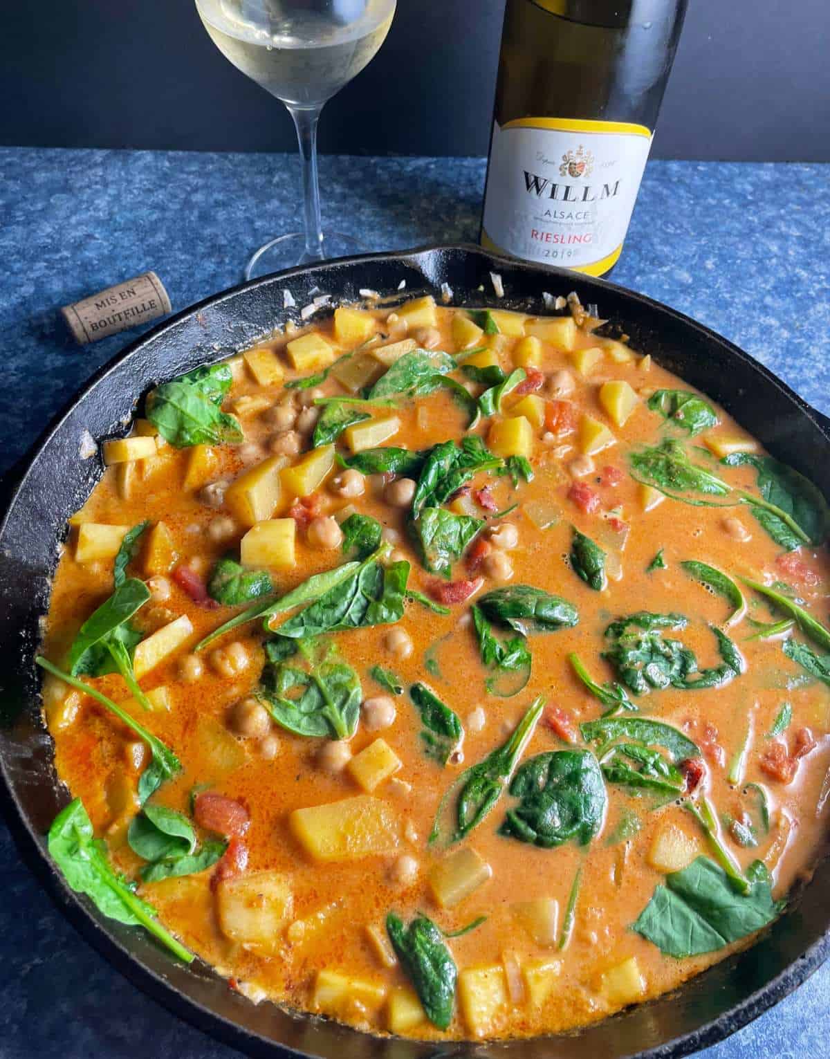 butternut squash chickpea curry in a large black skillet served with a Riesling white wine.