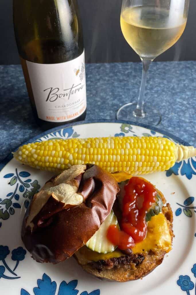 Veggie burger in a bun photographed from above, served with a Bonterra Chardonnay white wine.