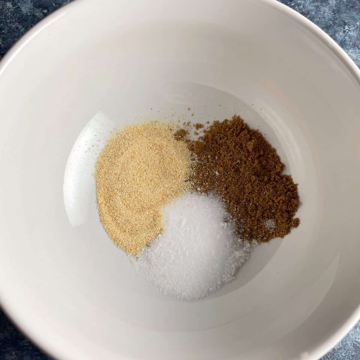 garlic powder, cumin and salt in a white bowl.