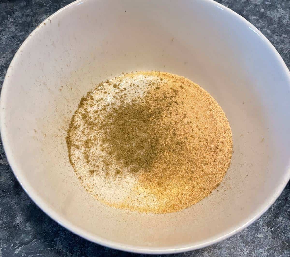 garlic powder and other spices in a bowl for a pork tenderloin dry spice rub.