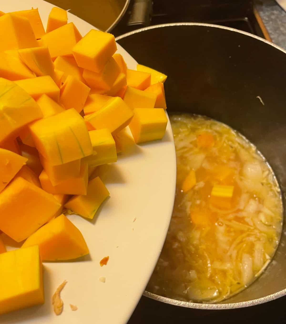adding butternut squash into pan