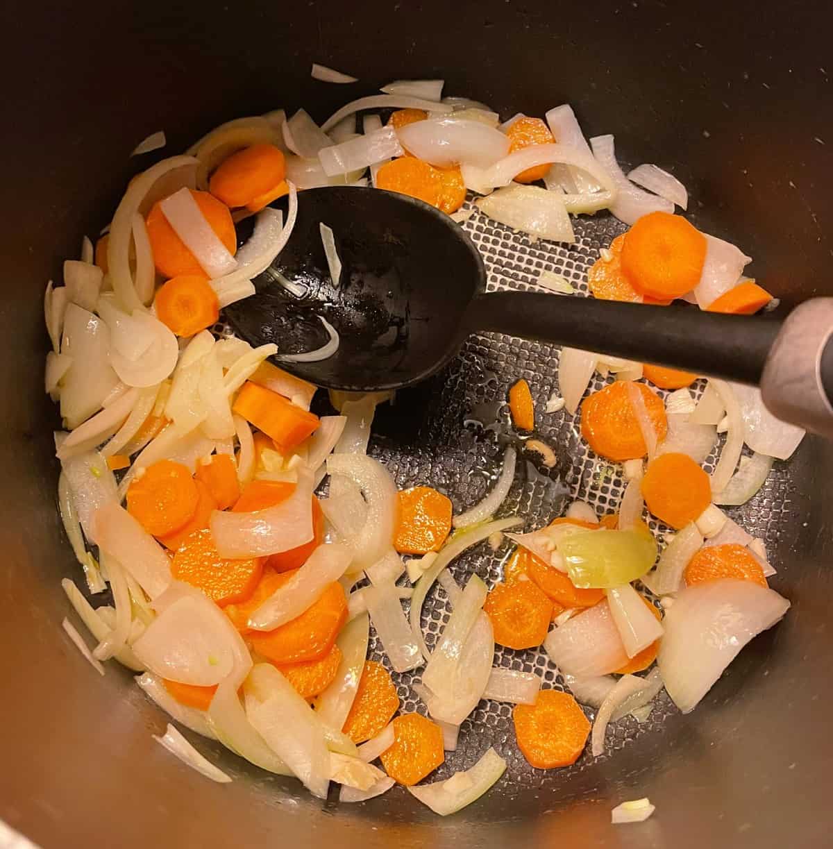 Stirring onions and carrots in pot
