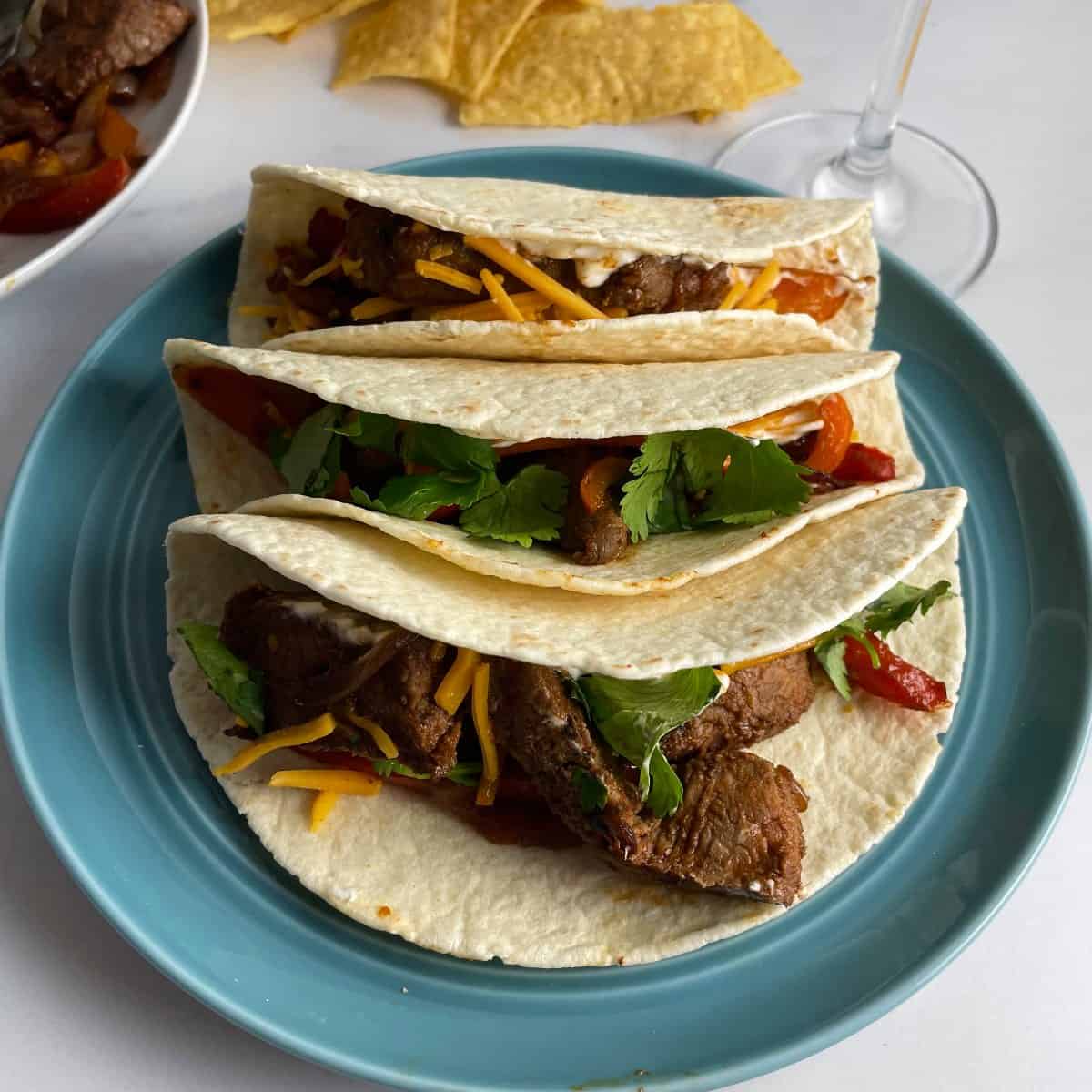 leftover steak fajitas served on a turquoise plate