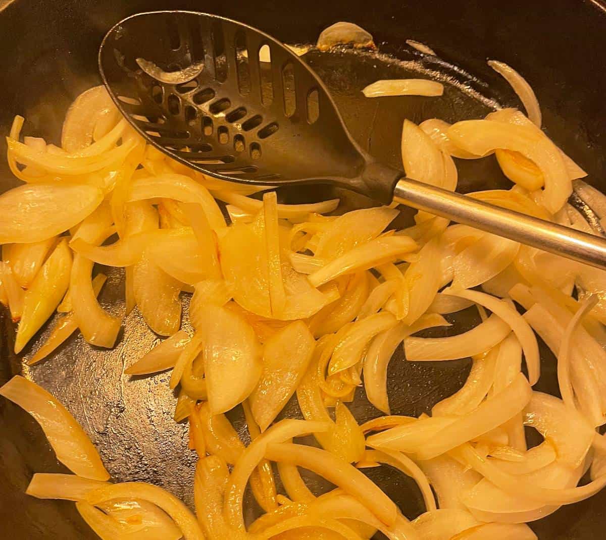 cooking onions in a large black skillet.