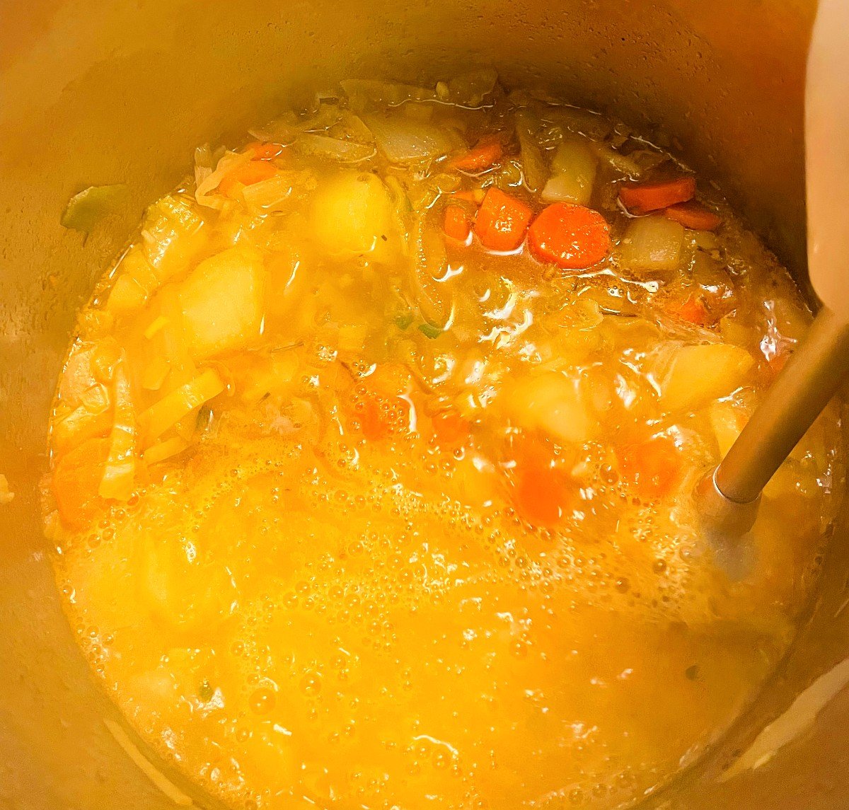 pureeing Irish vegetable soup with an immersion blender.