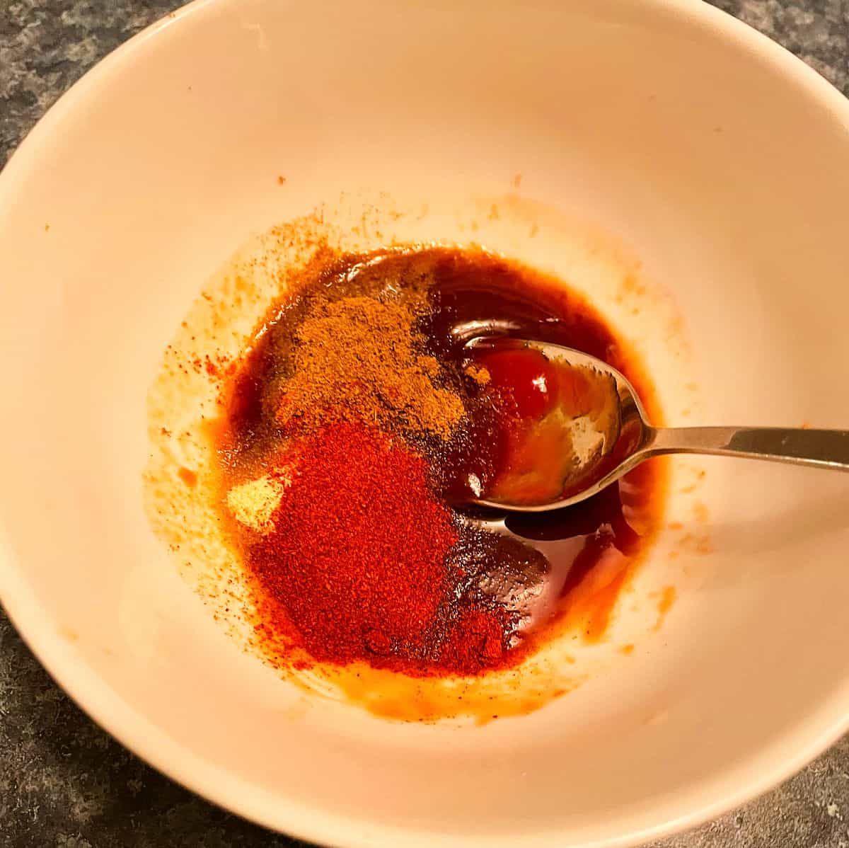 adding paprika and cumin to barbecue marinade.