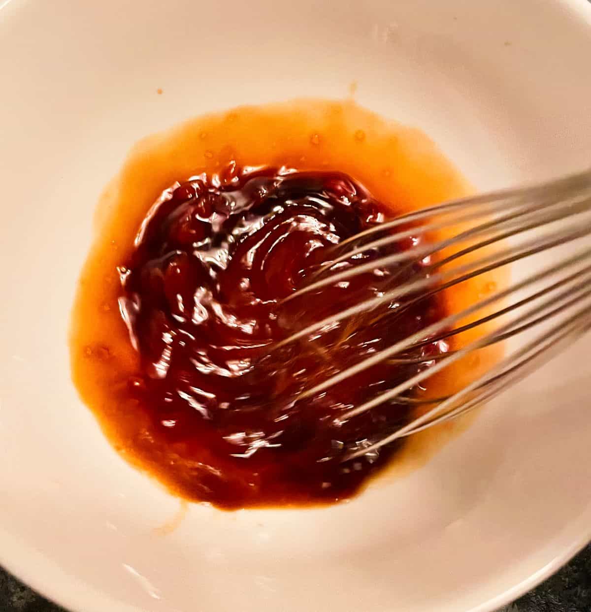 whisking soy sauce, ketchup and vinegar in a bowl. 