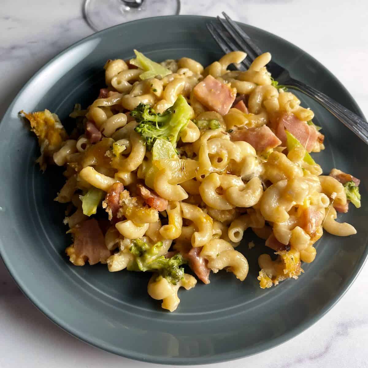 ham and cheese pasta bake on a drak gray plate.