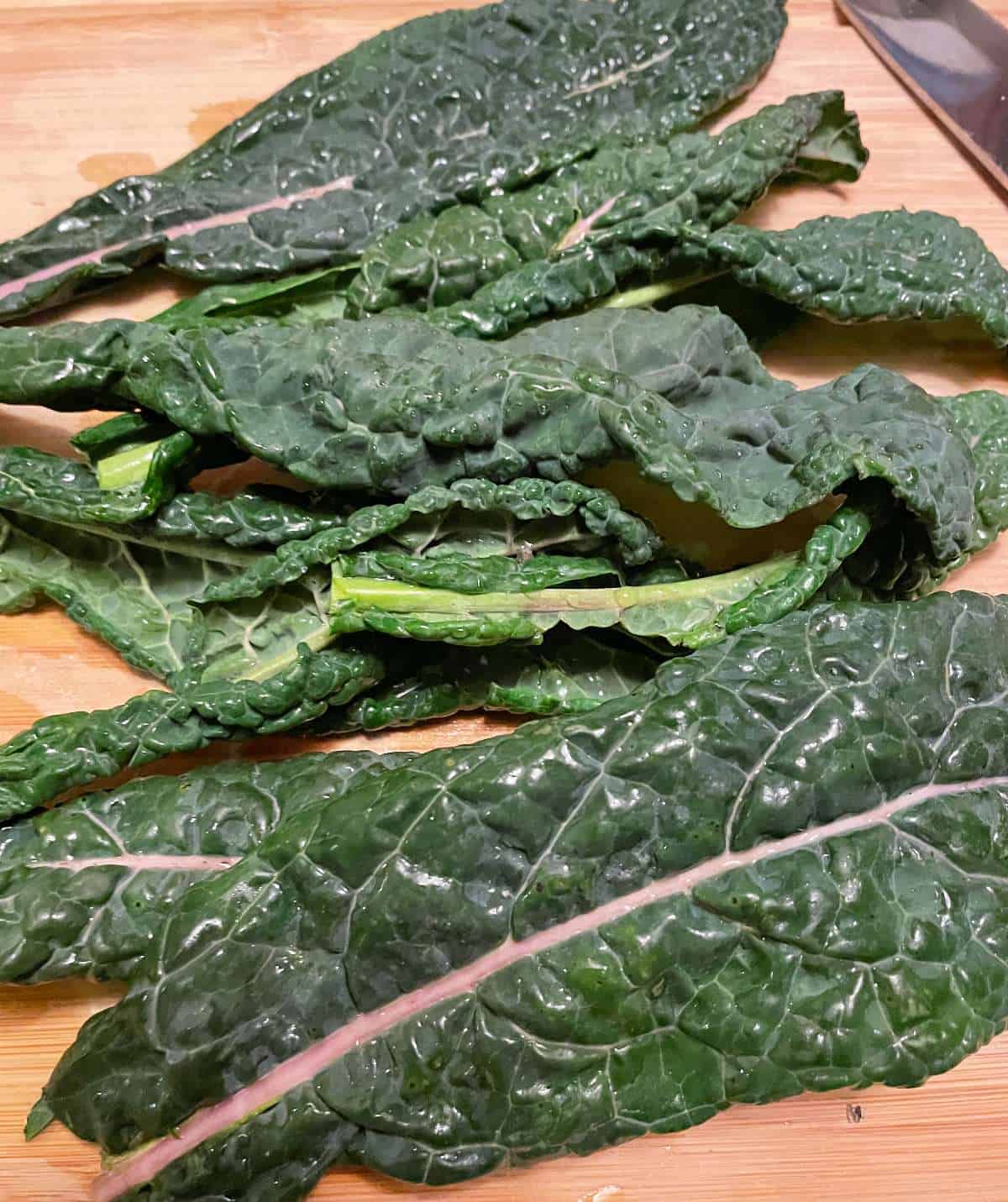 Lacinato kale on a wooden cutting board.