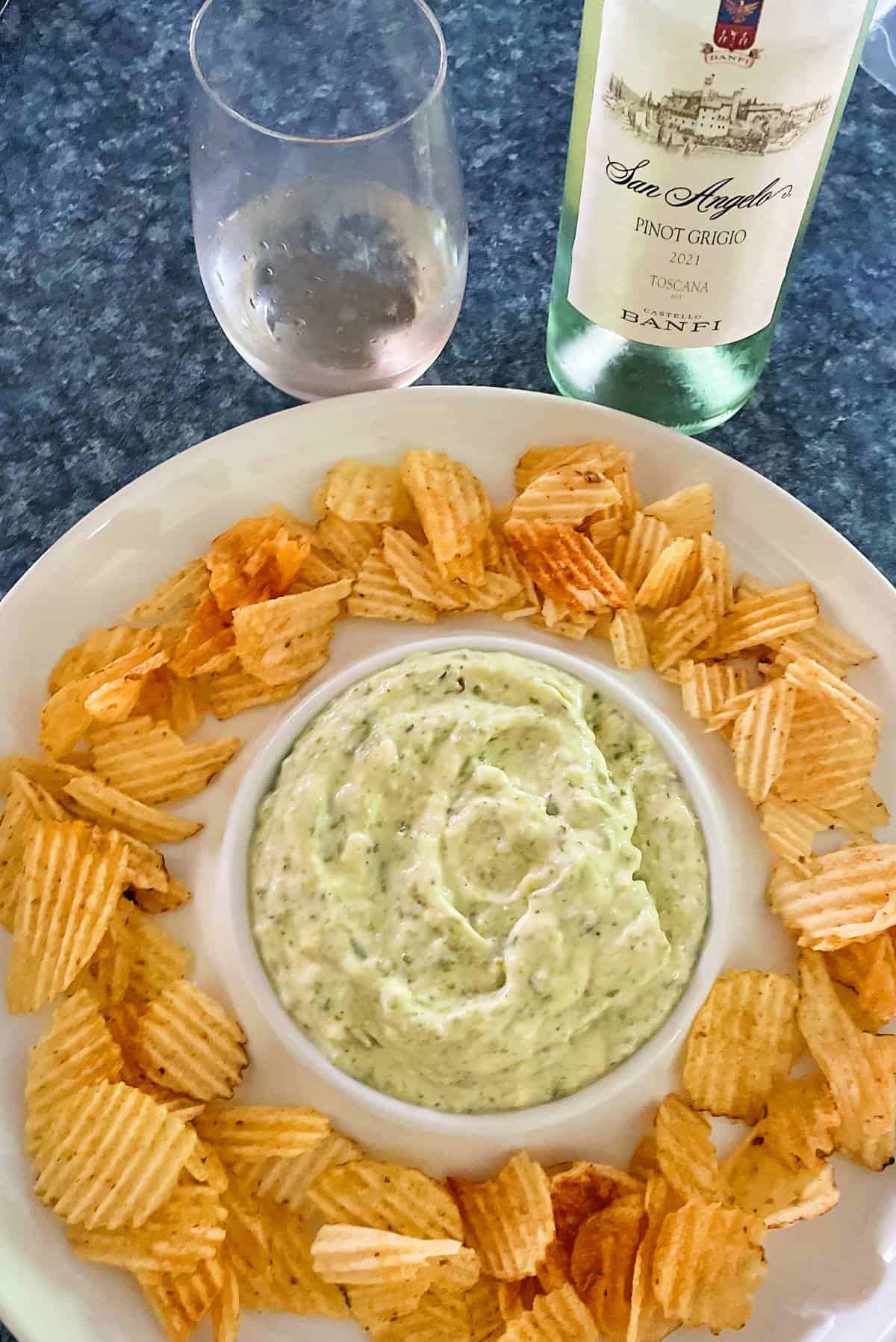 roasted asparagus dip in a serving bowl, with a bottle of Pinot Grigio white wine. 