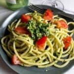 garlic scape pesto tossed with bucatini pasta and topped with tomatoes.