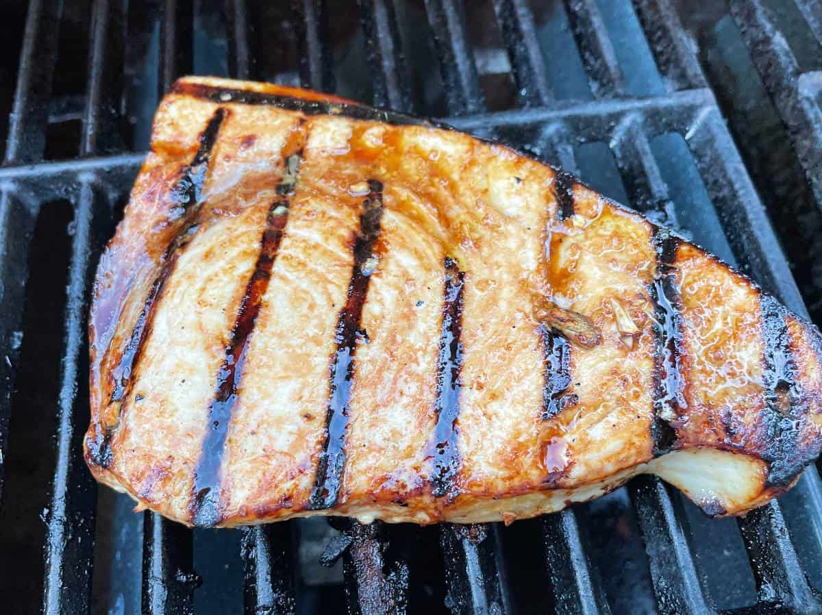 grilled swordfish with a garlic soy marinade, near the end of the grilling process. Grill marks showing on the fish.