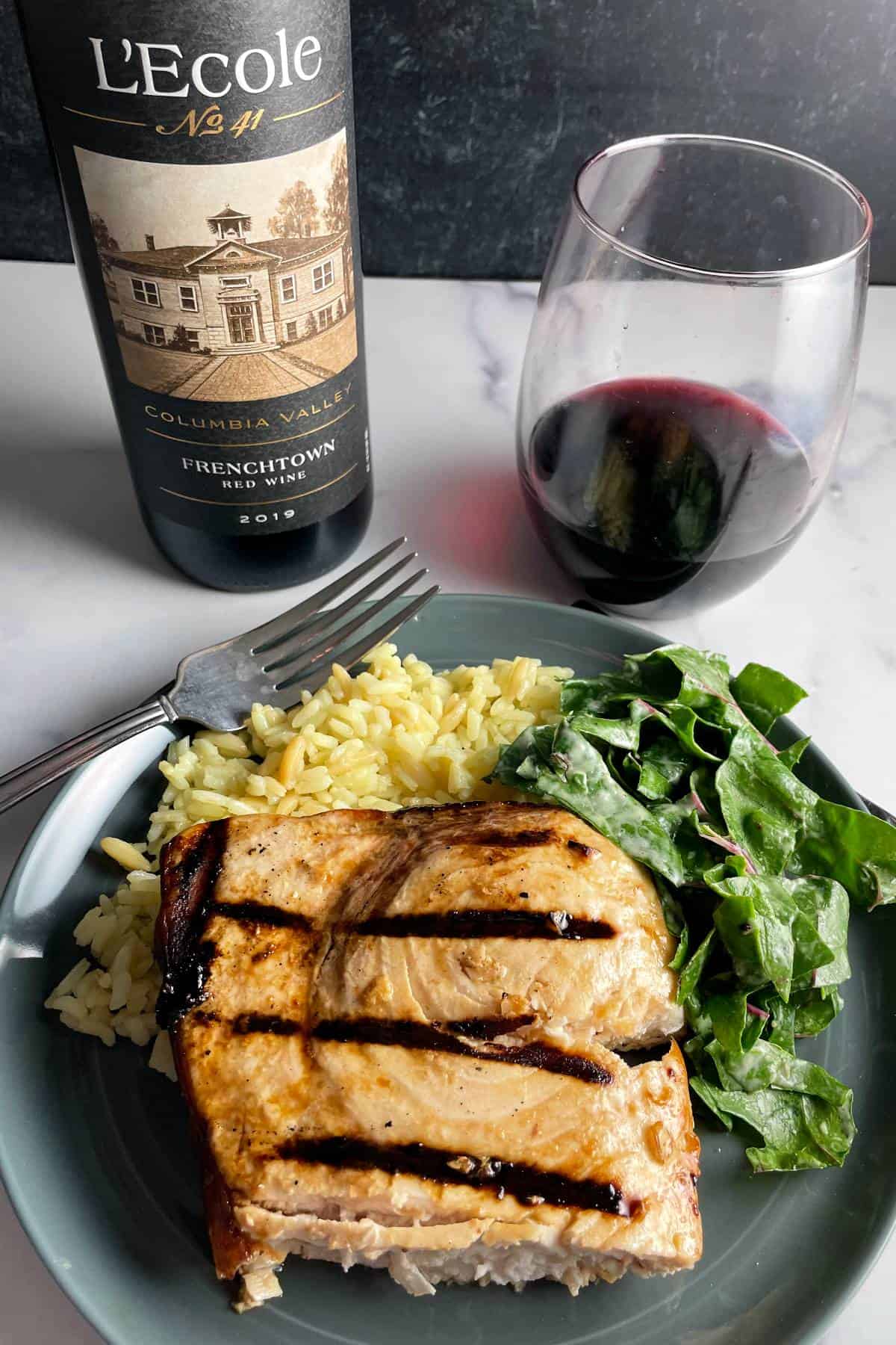 grilled swordfish served with rice pilaf, chard salad and a red wine.
