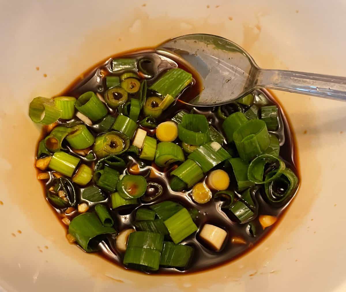 Stir fry sauce made with diced green onions in a small bowl.