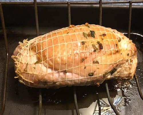 turkey breast, browned on the outside, on a rack in a roasting pan.