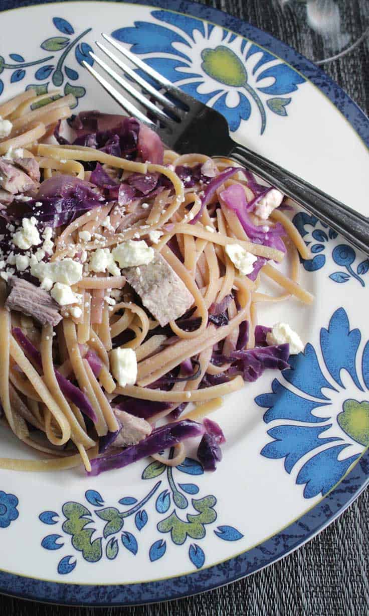 Linguine with red cabbage and leftover turkey on white plate with blue flowers on the edge.