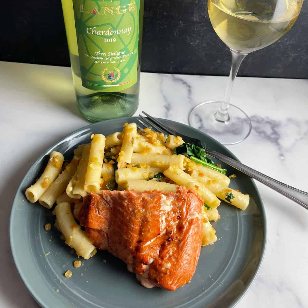 air fryer salmon plated with a pasta dish, and served with white wine.