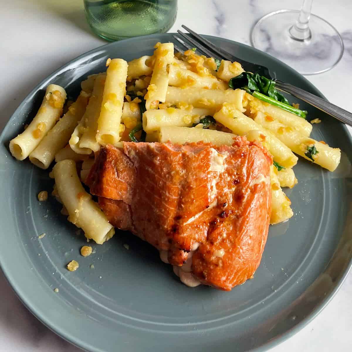 Air fryer salmon plated with ziti pasta.