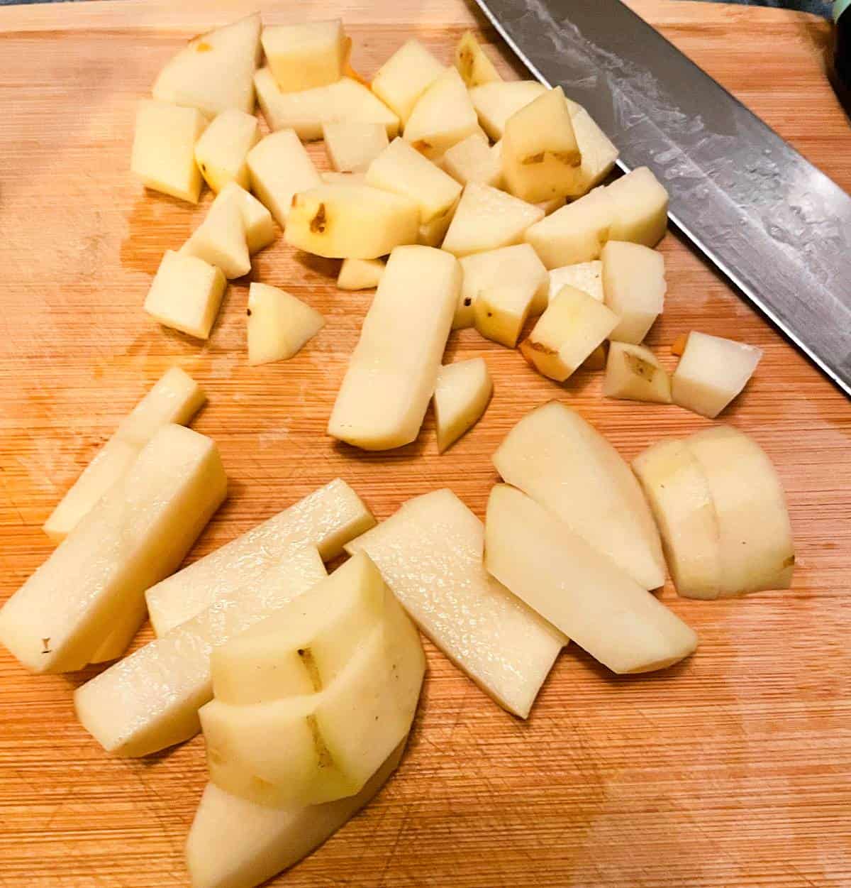 chopping potatoes on a cutting board.