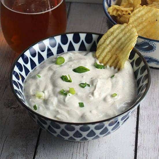 bowl of spicy green onion dip, made with sour cream and scallions.