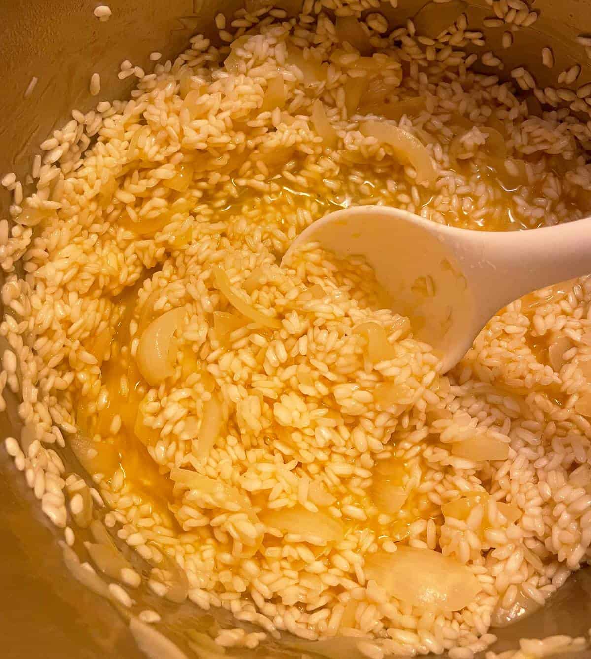 stirring risotto in a large pot.