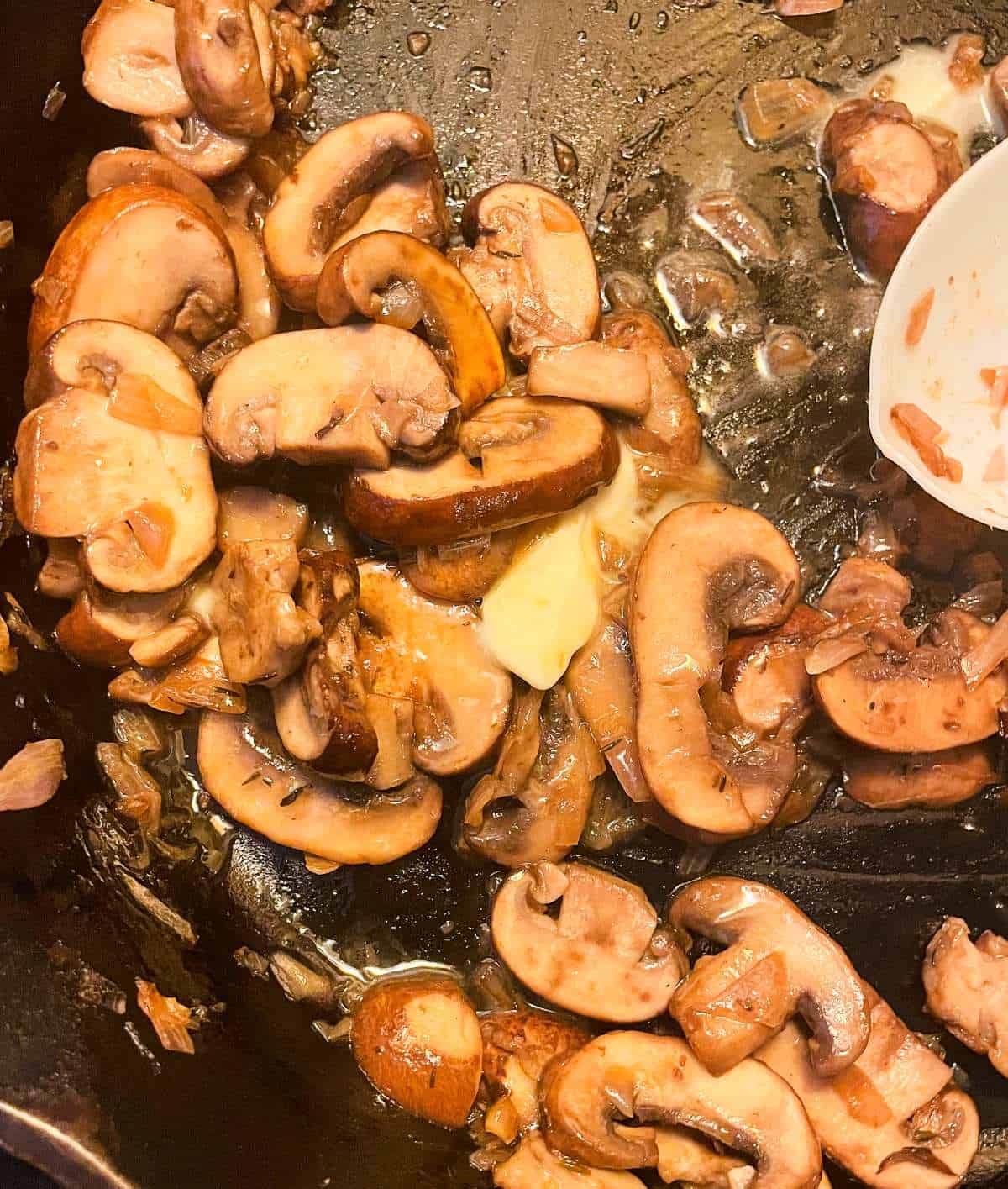 sautéing mushrooms in a black skillet.
