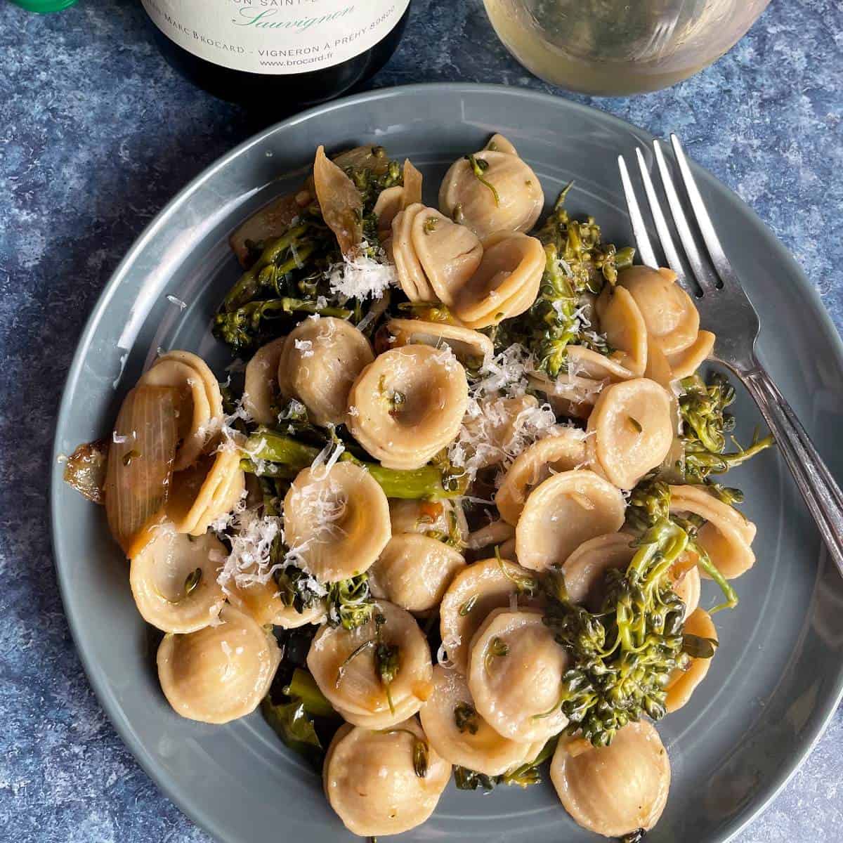 a plate with orrecchiette pasta with broccolini shot from above.