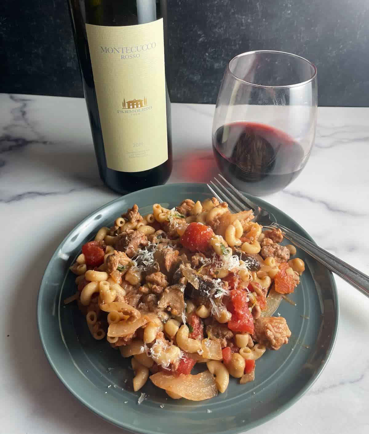 Gray plate with ground turkey pasta with tomatoes and mushrooms.