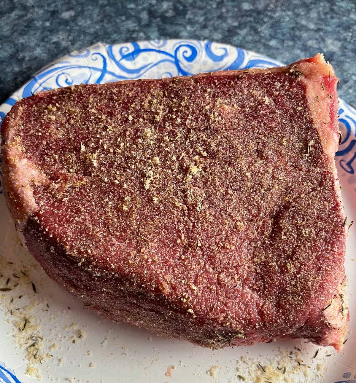 bottom round roast with a dry spice rub, on a plate.