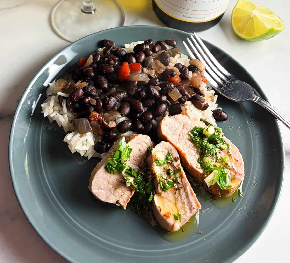 pork tenderloin topped with chimichurri, served with black beans and rice.