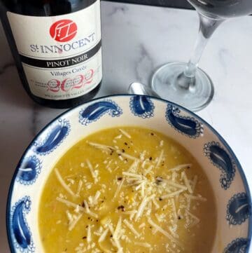 portion of a bowl of acorn squash soup along with a bottle of Willamette Valley Pinot Noir.