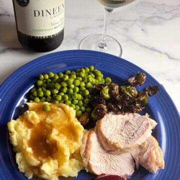 Turkey breast with mashed potatoes, peas, and Brussels sprouts paired with Dineen Vineyards white wine.
