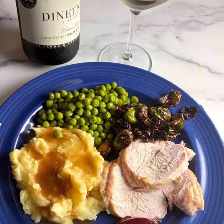 Turkey breast with mashed potatoes, peas, and Brussels sprouts paired with Dineen Vineyards white wine.