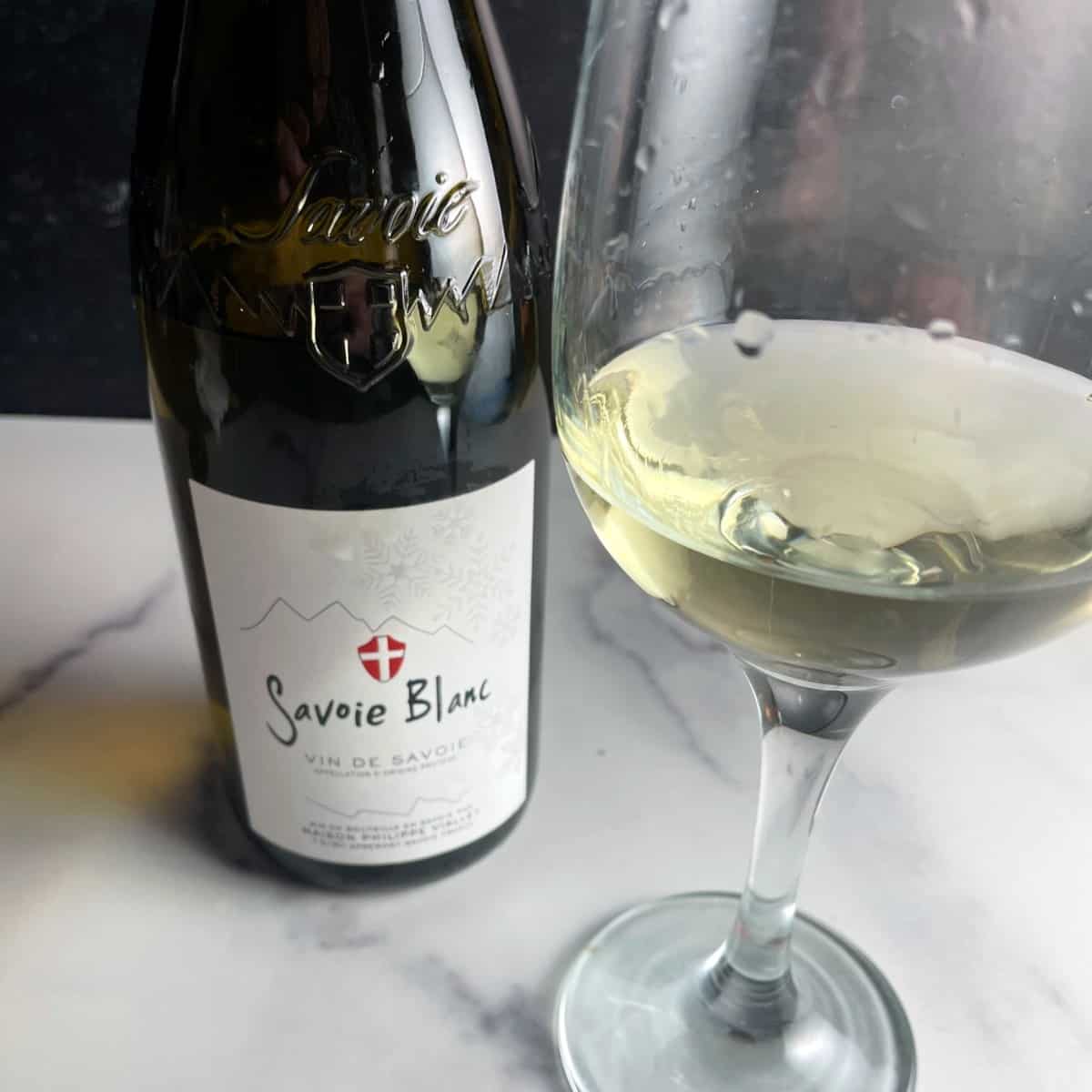 A bottle and glass of Vin de Savoie Blanc wine.