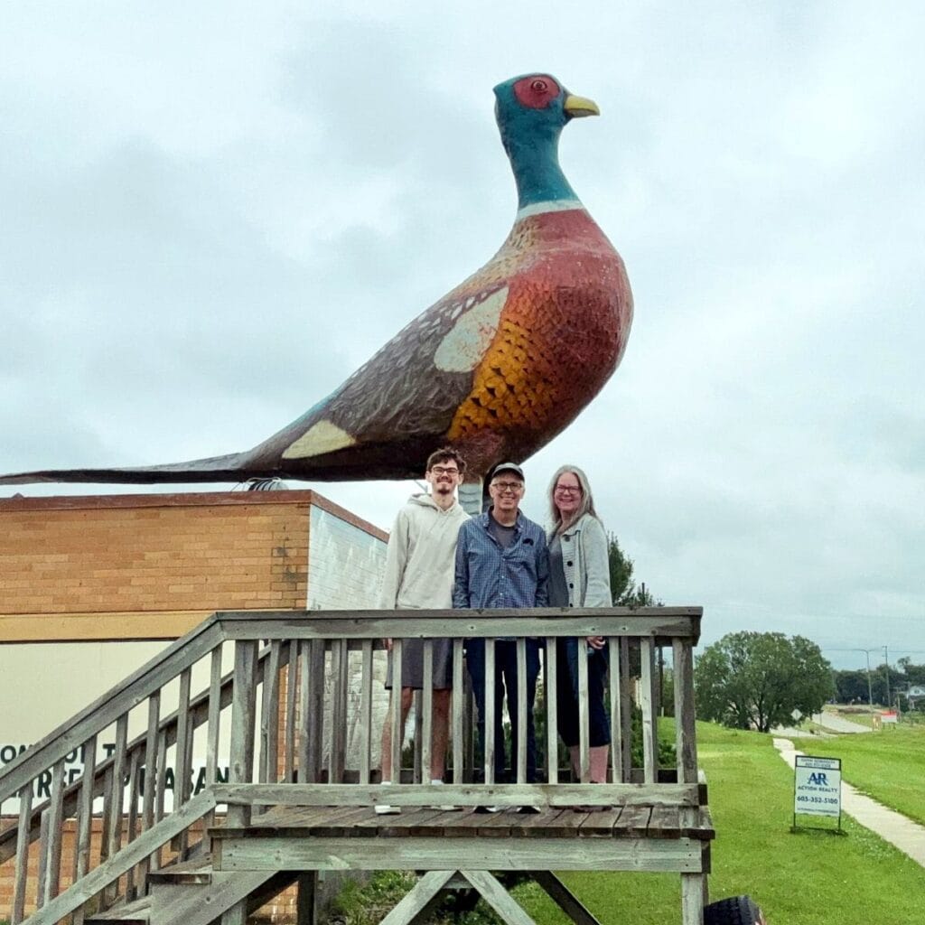family selfie in front of the world's largest pheasant statue.