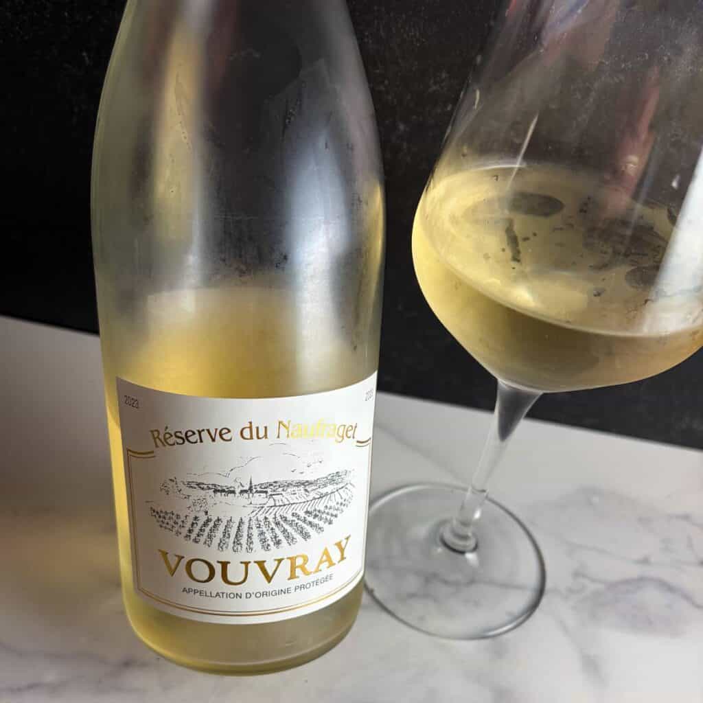 a glass of Vouvray with the bottle next to it.