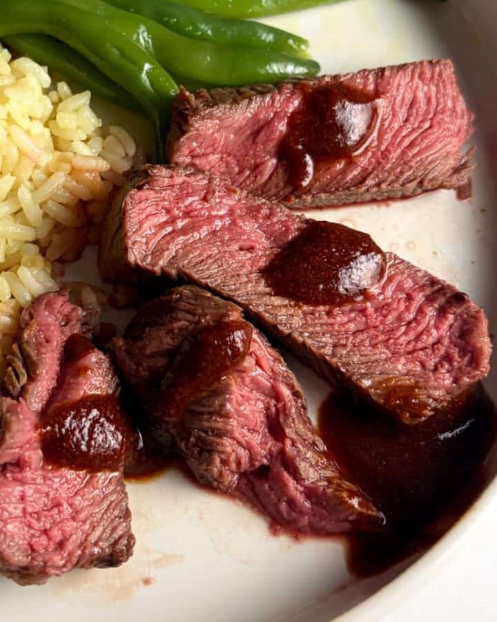 Denver steak slides served with BBQ sauce, rice and green beans.