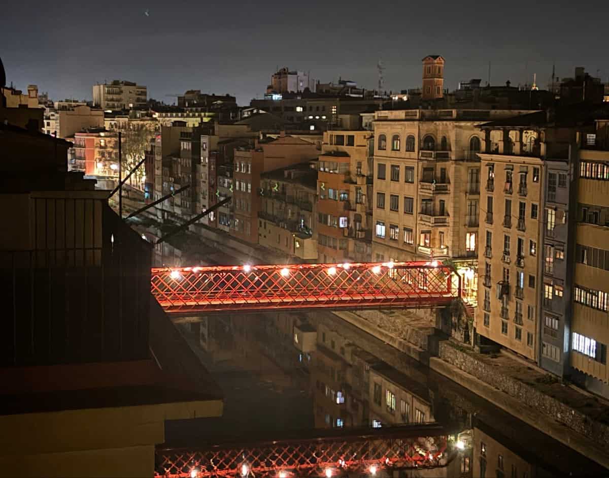 Girona's Eiffel Bridge, lit up at night time.