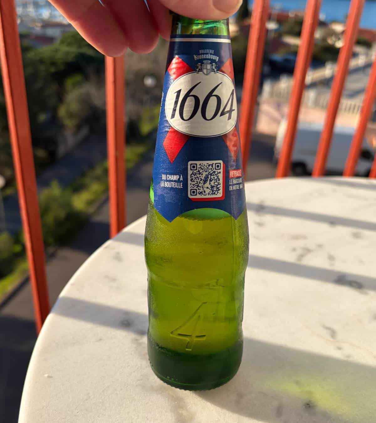 Kronenbourg 1164 lager bottle on a patio table.