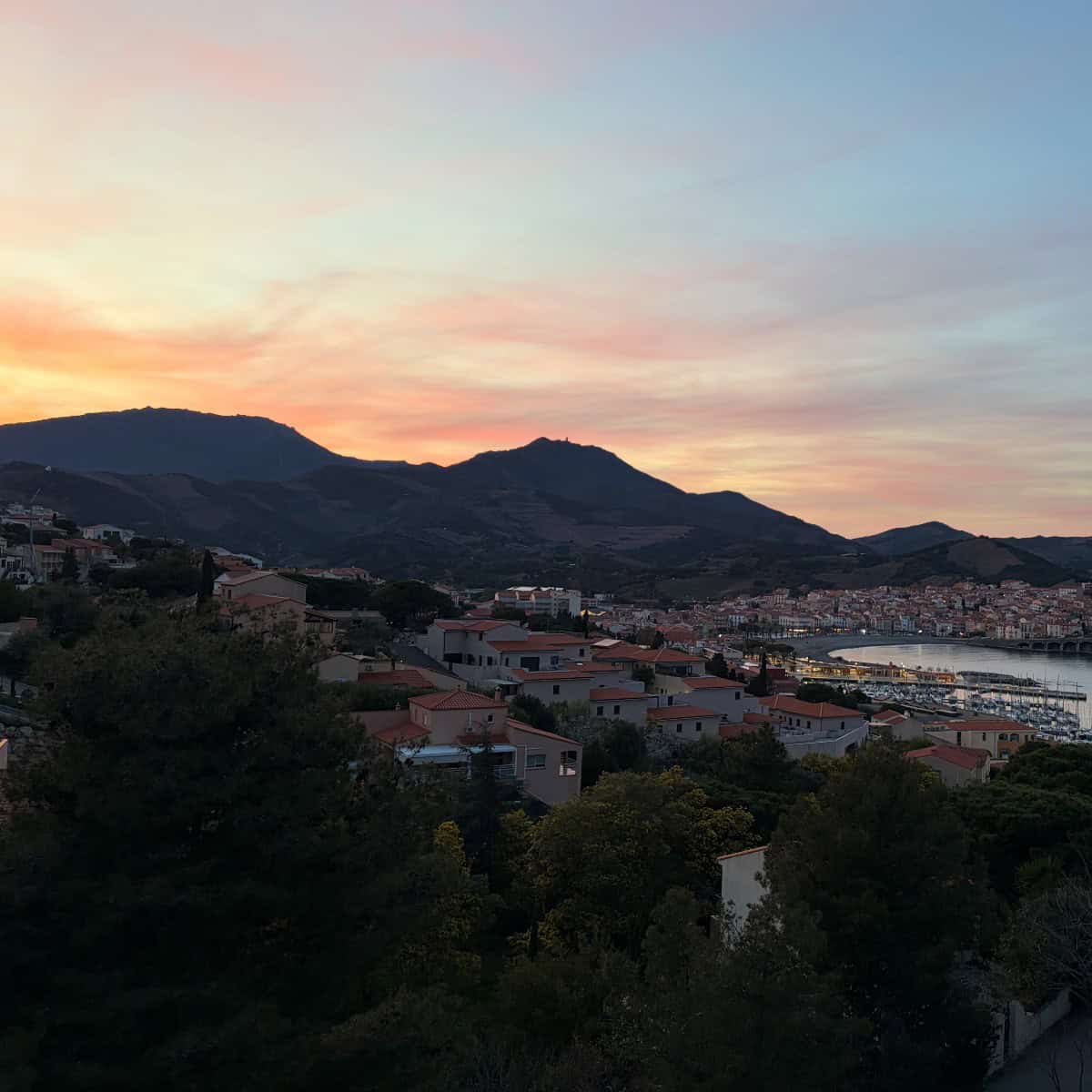 sun setting behind mountains in Banyul-sur-Mer.