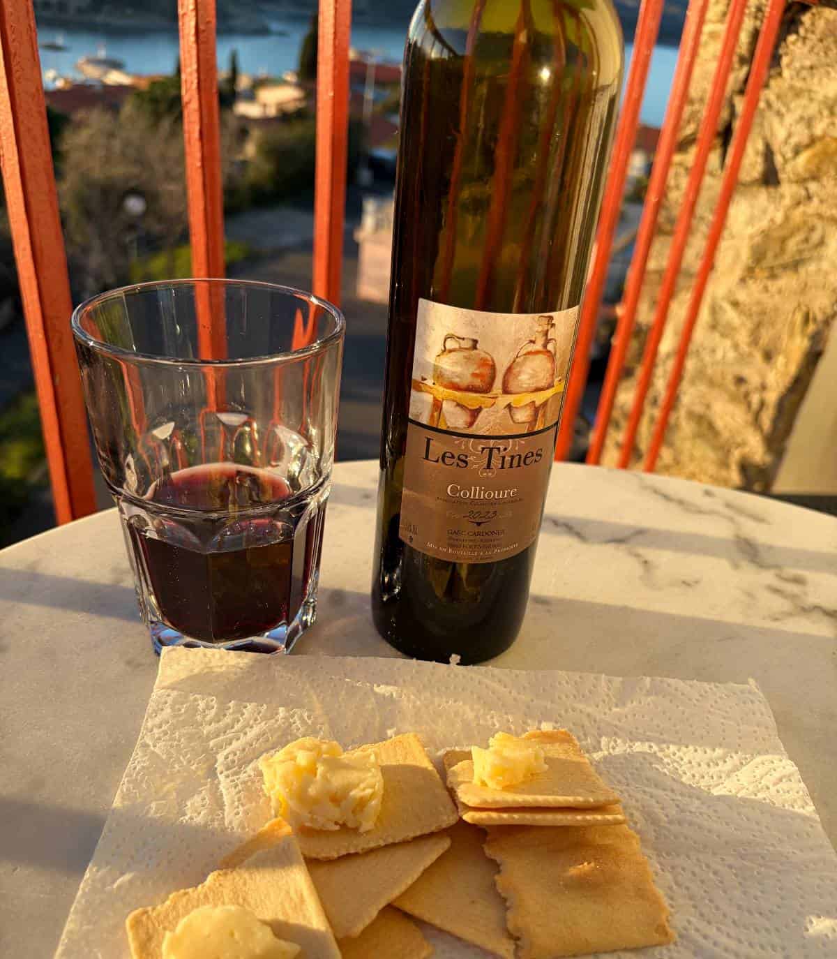 cheese and crackers with a red wine, on a patio table.