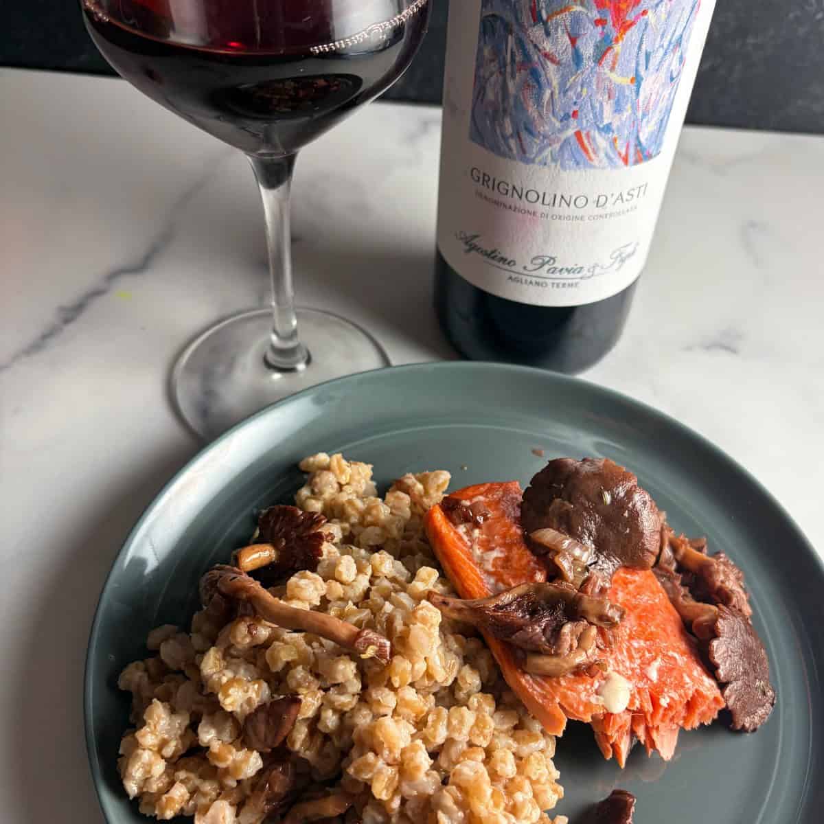 salmon topped with wild mushrooms and served with farro, and a red wine.