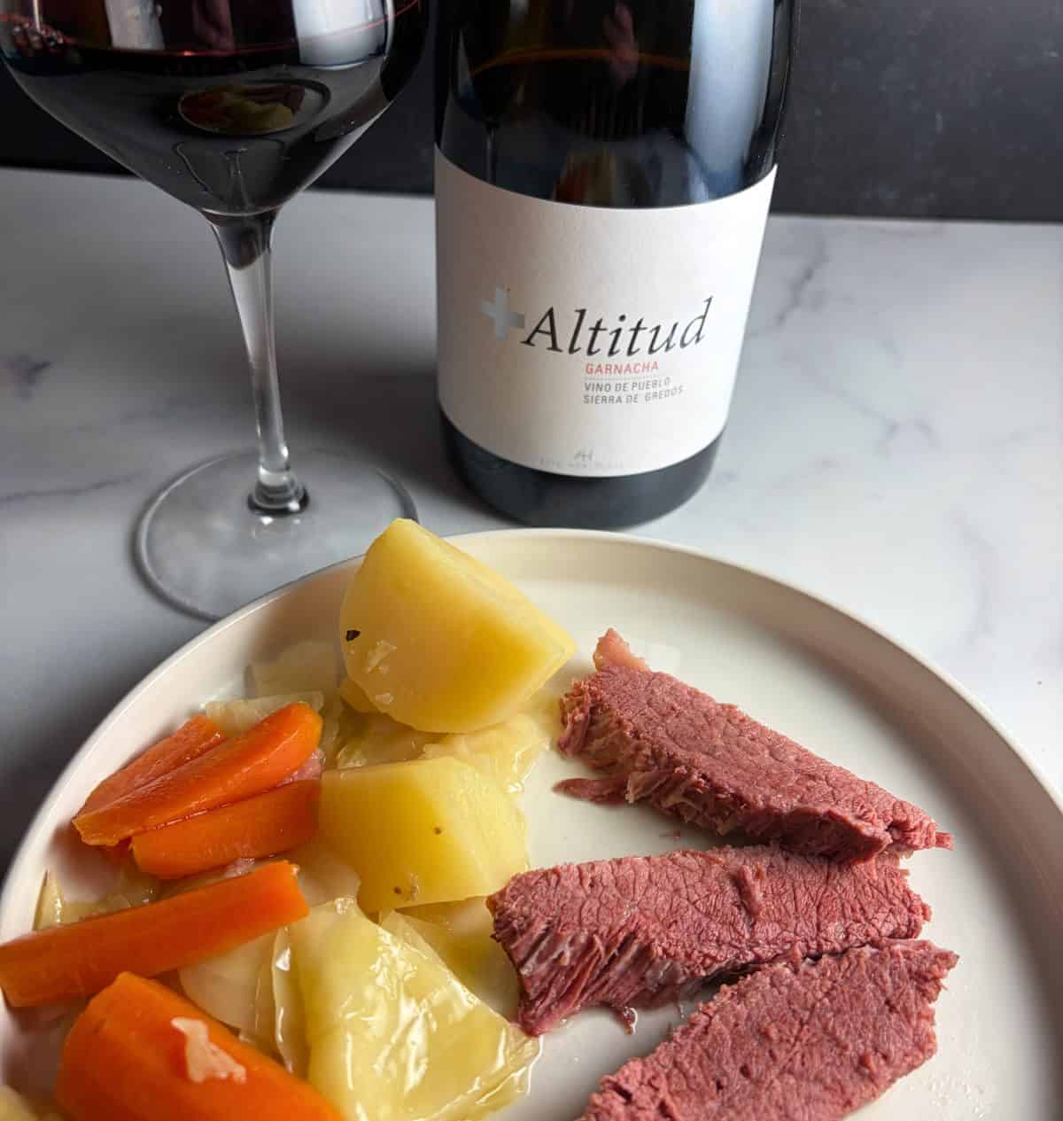 plate with corned beef and boiled vegetables, served with a Garnacha.