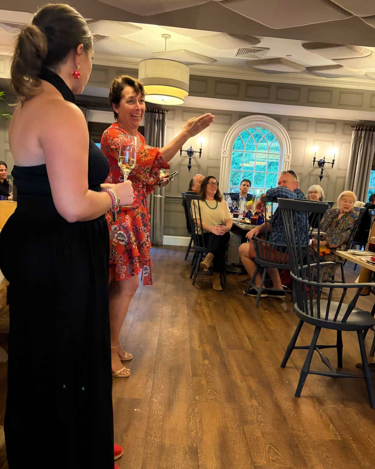 woman speaking at a wine dinner.